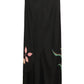 The Seductive Bloom Skirt by Dorothee Schumacher is a black bias-cut skirt with a straight silhouette, featuring a pink leaf on the left and a green abstract motif on the right.