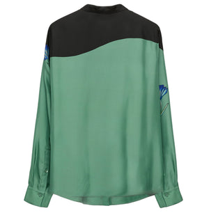The Seductive Bloom Blouse by Dorothee Schumacher features a green body, black upper back, and subtle blue floral sleeve accents for a timeless style.