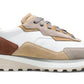 A side view of the Magnanni Onyx Sneaker, featuring white, beige, tan, and onyx brown suede and leather panels with a chunky sole and grey laces, highlighting its refined luxury design.