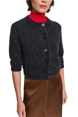 A woman wears the Dorothee Schumacher Fluffy Statements Cardigan in dark gray over a red turtleneck and brown skirt, shown from shoulders to mid-thigh.