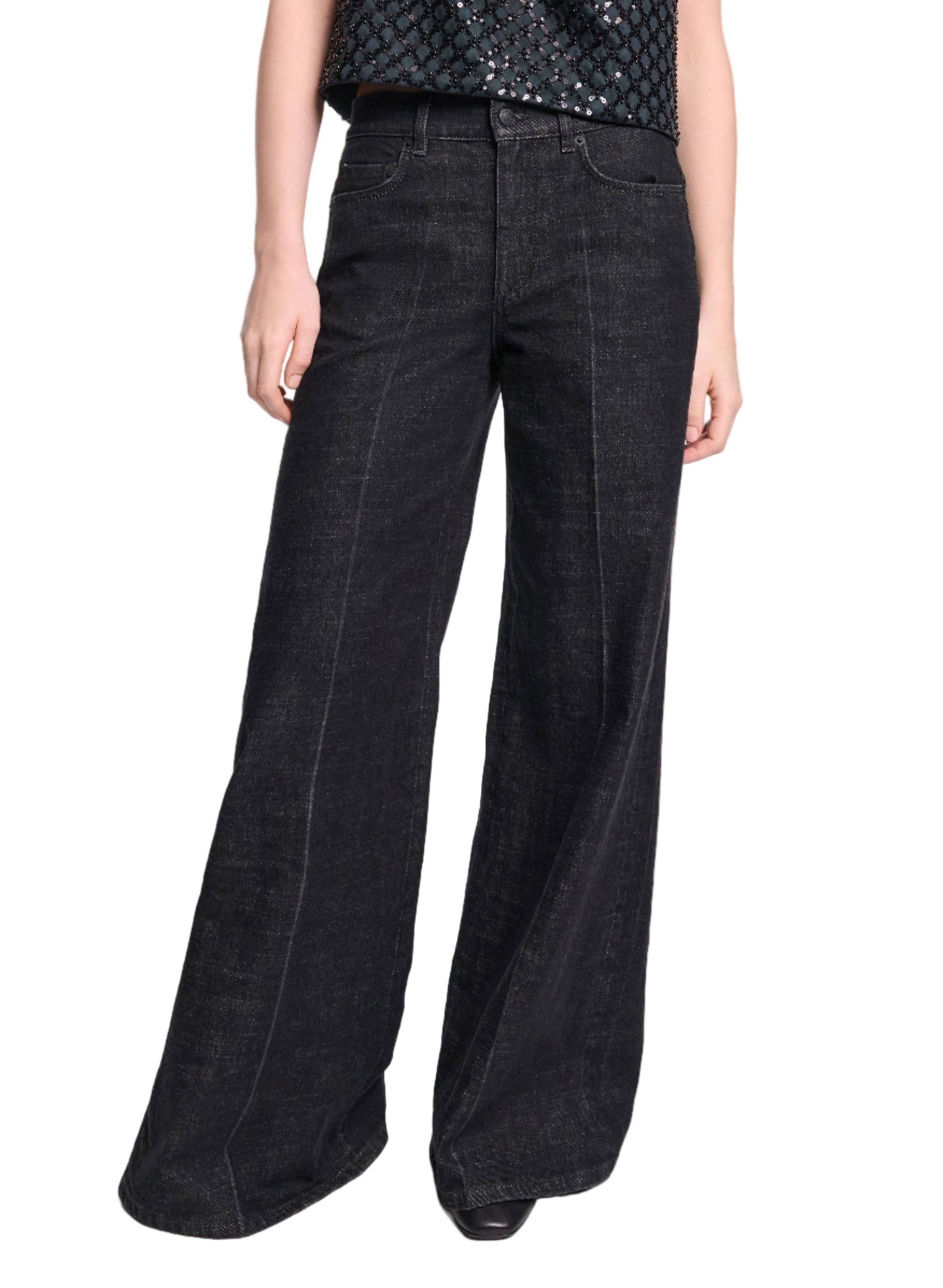 Model wears the Deep Love Pants by Dorothee Schumacher—wide-leg, dark wash black jeans—paired with a textured black top, set against a white background.