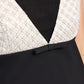Close-up of the Dorothee Schumacher Emotional Essence Dress featuring a textured white and black geometric bodice, deep V-neckline, and a small black bow at the waist.