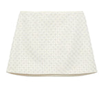 The Dorothee Schumacher Sparkling Statement Mini Skirt is a white A-line piece with a textured geometric lace pattern on the front, offering a fresh, modern look.