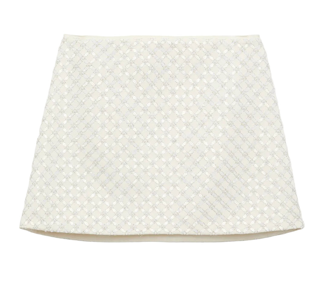 The Dorothee Schumacher Sparkling Statement Mini Skirt is a white A-line piece with a textured geometric lace pattern on the front, offering a fresh, modern look.