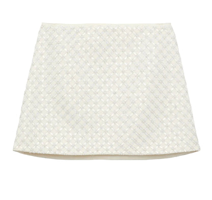 The Dorothee Schumacher Sparkling Statement Mini Skirt is a white A-line piece with a textured geometric lace pattern on the front, offering a fresh, modern look.