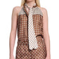 A woman wears the Dorothee Schumacher Graphic Dreams Top, a brown patterned silk twill sleeveless piece with a white tie, paired with matching high-waisted pants featuring signature prints, standing against a plain background.