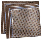 The Eton Geometric Silk Twill Pocket Square showcases a brown silk twill design with an Italian-printed blue and white hexagonal geometric pattern, a light blue border, and the "Eton" logo elegantly printed in one corner.