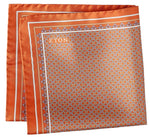 The Geometric Silk Twill Pocket Square by Eton features an orange patterned silk twill fabric, accented with a white border and a repeating hexagonal geometric motif. The elegantly printed brand name "Eton" appears in white on one corner.