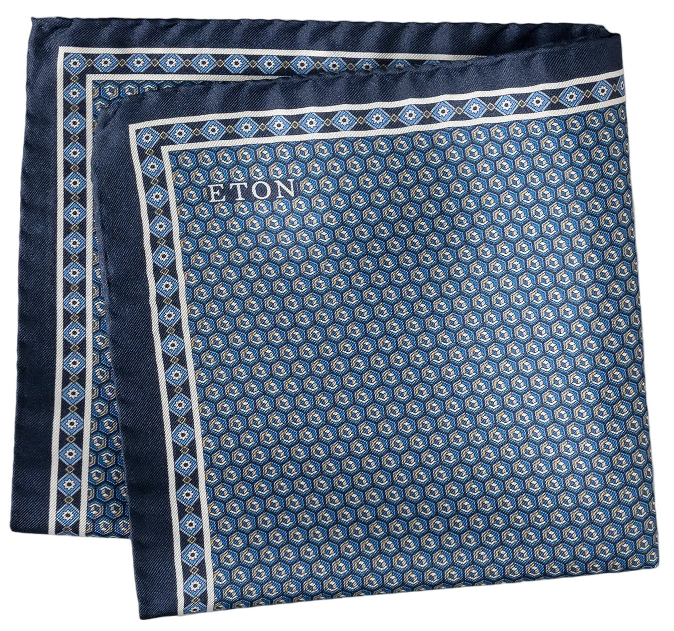 A folded Geometric Silk Twill Pocket Square by Eton, featuring a sophisticated blue hexagonal pattern and a discreet "Eton" logo in one corner, Italian printed for an elegant finish.