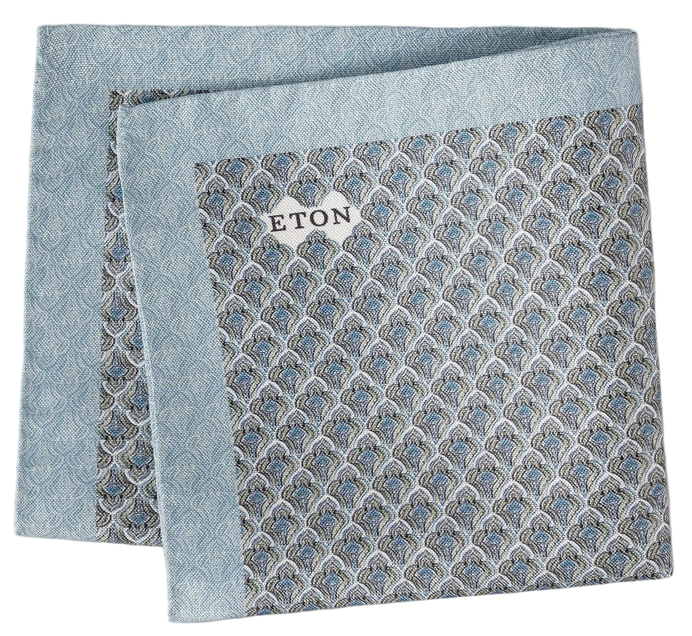 Light blue Geometric Silk Oxford Pocket Square from Eton, featuring a striking geometric motif and a small white brand tag. Expertly folded to showcase its elegant Oxford-woven silk finish with visible edges.