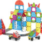 The Magnatiles City Center 110-Piece Set features vibrant magnetic tiles that assemble into a castle structure, complete with two toy cars and a curved road track in front.