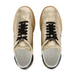 The Isabel Marant Kaycee Sneaker, crafted from light gold metallic leather, includes black laces and white interiors. From above, the brown soles and black heel accents add a striking touch to this stylish pair.