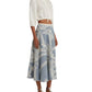 A person in a white cropped top and blue and white Emporio Sirenuse Tasha Palm Embroidery Skirt stands in sandals against a white background.