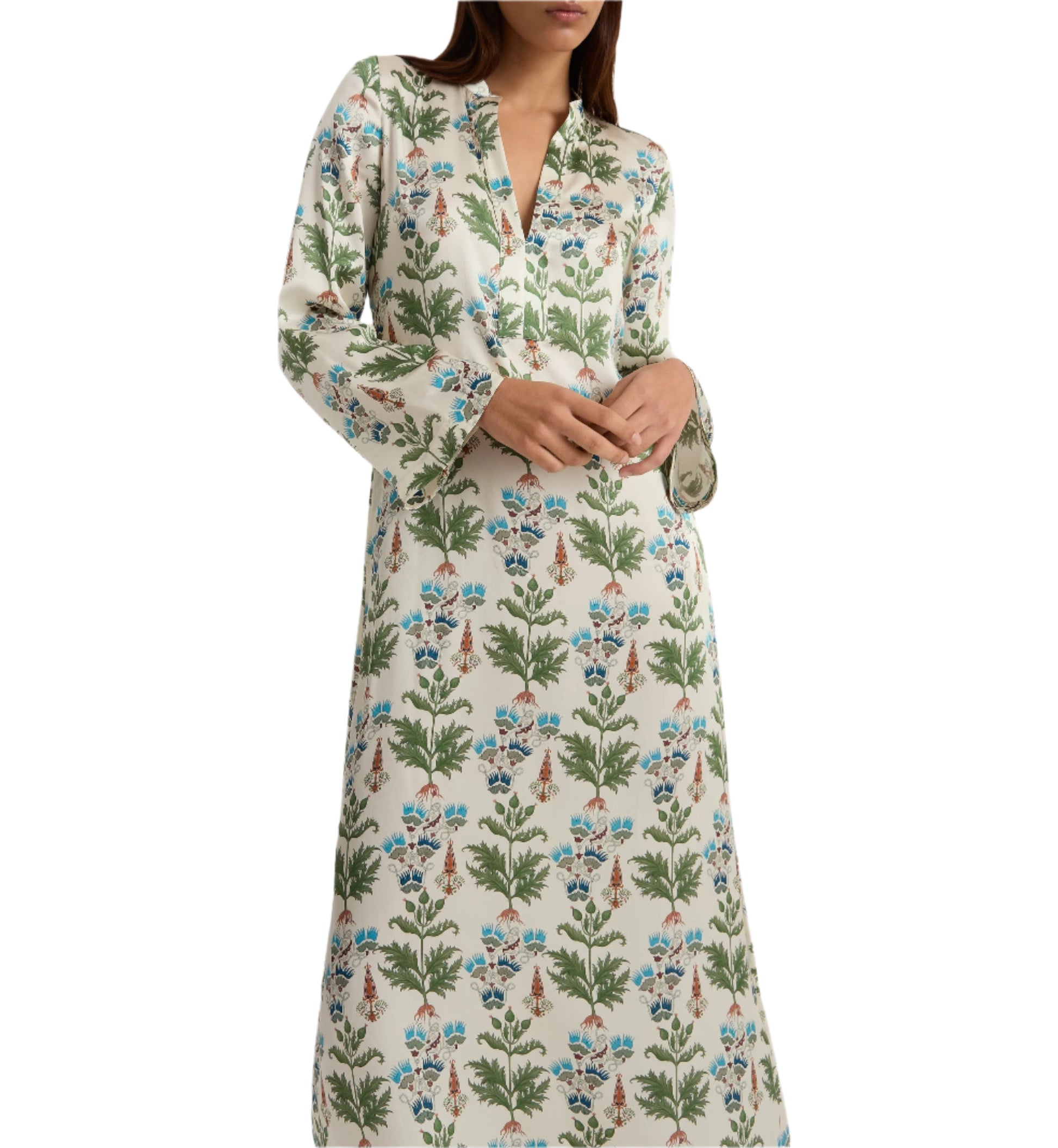 A person wearing the Emporio Sirenuse Jenna Persian Botanic Silk Dress, featuring elegant green and blue floral patterns with graceful bell sleeves, stands against a plain white background.