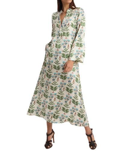 A person wearing the Emporio Sirenuse Jenna Persian Botanic Silk Dress with floral patterns and bell sleeves, paired with black high-heeled sandals.