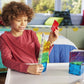 A child smiles while building a colorful structure with the Magnatiles Rail Racers 33-Piece Set, a STEM toy, in their bedroom.