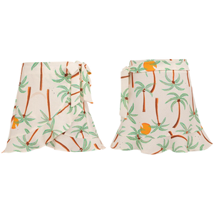 Front and back views of the Pepita & Me Girls' Marea Skirt—a comfy white skirt with palm tree and orange fruit print, side-tied. Perfect summer wear for girls.