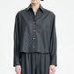 A person wearing the Maria McManus Button Sleeve Crop Shirt in dark gray wool flannel with matching pants, standing against a plain light background.