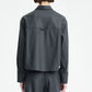 A person stands with their back to the camera, wearing the Maria McManus Button Sleeve Crop Shirt in dark gray wool flannel with a cropped silhouette, paired with matching trousers, set against a plain white background.