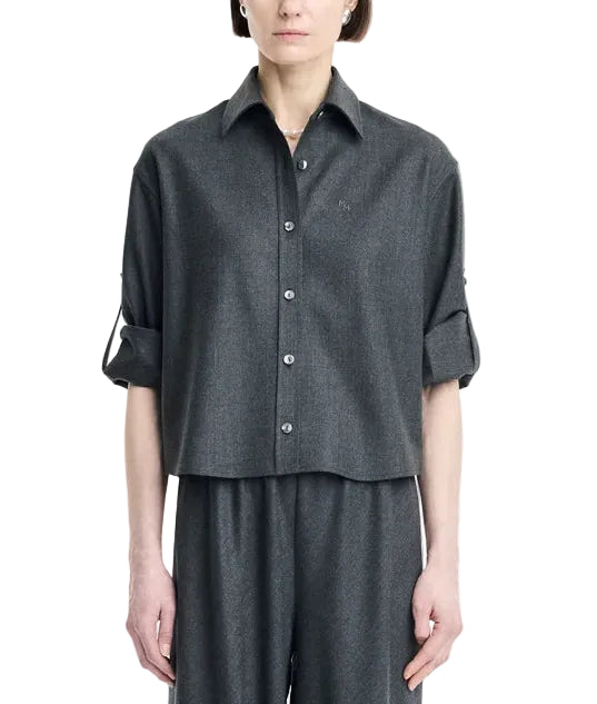A person wearing the Maria McManus Button Sleeve Crop Shirt in dark gray wool flannel, featuring a cropped silhouette and rolled-up button sleeves, paired with matching wide-leg pants and standing against a plain white background.