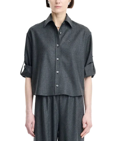 A person wearing the Maria McManus Button Sleeve Crop Shirt in dark gray wool flannel, featuring a cropped silhouette and rolled-up button sleeves, paired with matching wide-leg pants and standing against a plain white background.