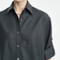 A woman stands against a plain background wearing the Maria McManus Button Sleeve Crop Shirt in charcoal gray wool flannel, styled with rolled sleeves and a pearl necklace.