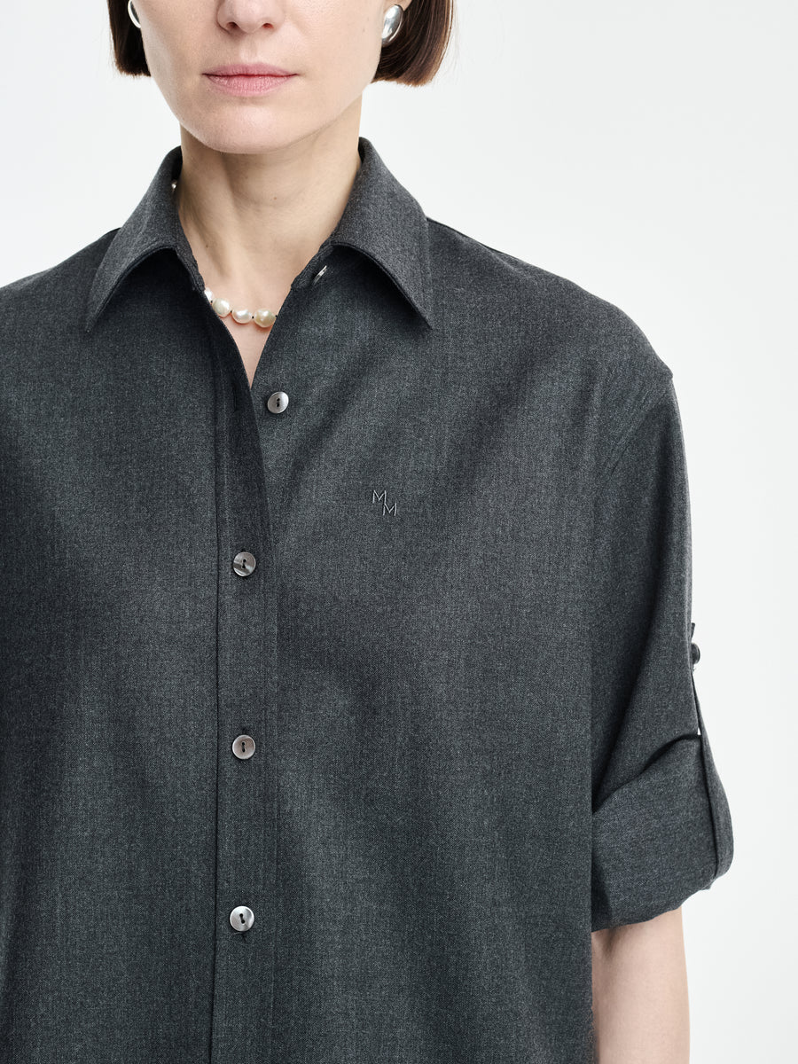 A woman stands against a plain background wearing the Maria McManus Button Sleeve Crop Shirt in charcoal gray wool flannel, styled with rolled sleeves and a pearl necklace.