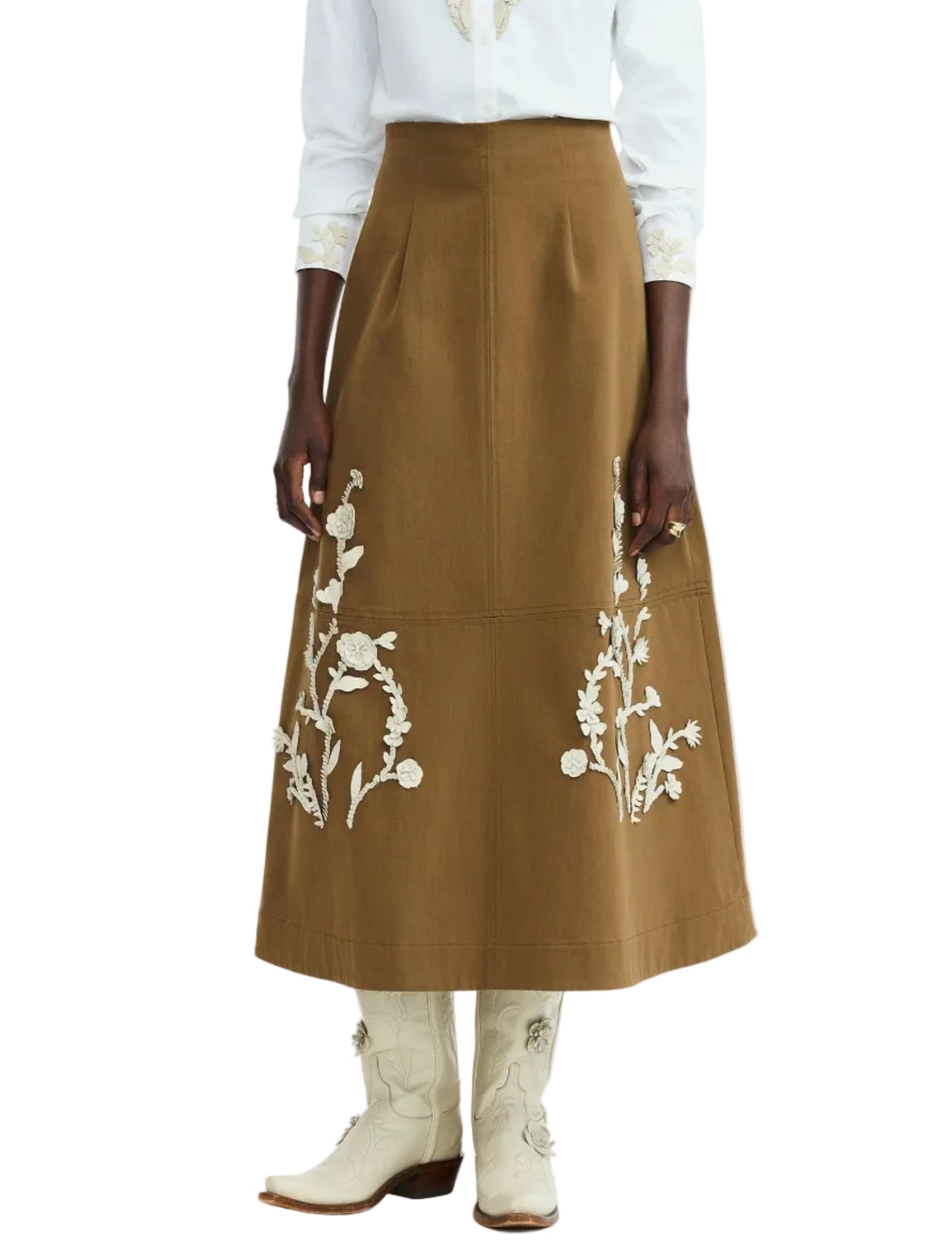 A person wearing the Lela Rose Leather Floral Embroidered Rustic Skirt, a white shirt, and white cowboy boots.