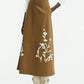 A person in the Lela Rose Leather Floral Embroidered Rustic Skirt, crisp white shirt, and white cowboy boots stands against a plain background.
