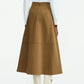 A person is seen from the back wearing a white long-sleeve shirt, the Lela Rose Leather Floral Embroidered Rustic Skirt in brown, and white cowboy boots, set against a plain background.