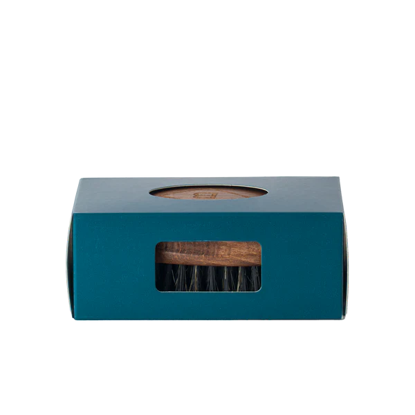 The Barberino's Beard Brush with natural bristles is partially visible through the rectangular window of its teal box, which features a circular cutout on top.