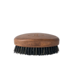 The Barberino's Beard Brush is a small oval brush with a wooden handle and dark natural bristles, ideal for grooming your beard. Shown against a plain white background.