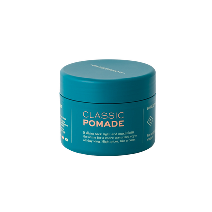 A teal jar of BRB Classic Pomade by Barberino's with white and orange text, featuring medium hold for gentlemen's grooming, is shown against a plain white background.