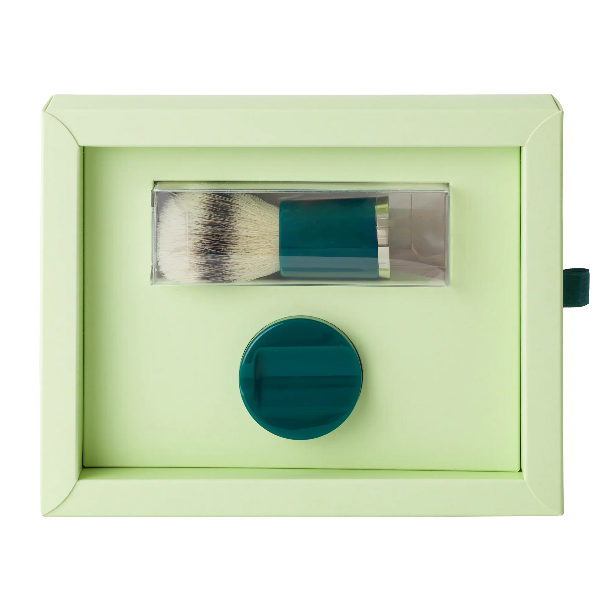 Barberino's Cruelty Free Shaving Brush in a clear holder and round teal lathering container, set on a light green background—ideal for an elevated, traditional shaving experience.