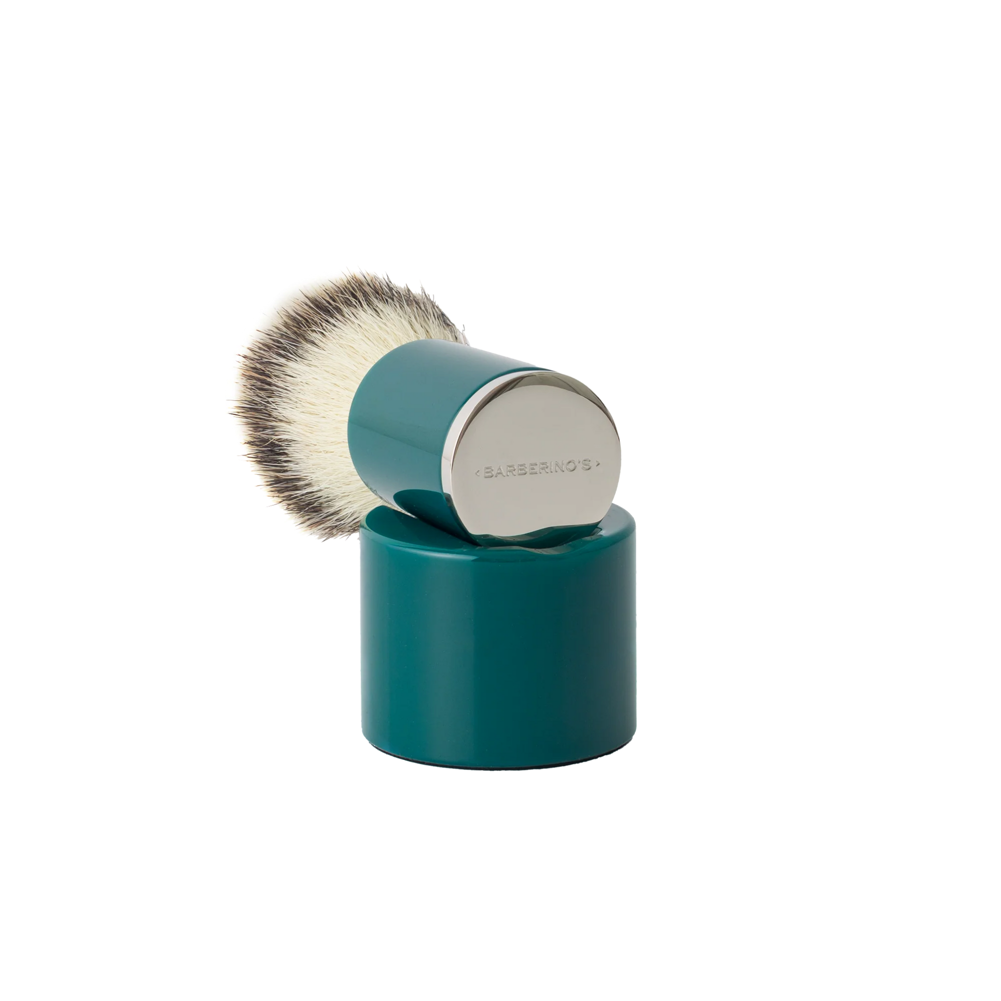 The Barberino's Cruelty Free Shaving Brush features a teal synthetic bristle brush with a cylindrical handle and silver cap, resting upright on a matching teal stand—ideal for a traditional shaving experience.