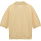 The Refined Essentials Pullover by Dorothee Schumacher is a light yellow short-sleeve stretch cotton sweater featuring ribbed collar, cuffs, and hem, shown flat with the back facing forward.