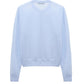 The Sheer Summer Twinset by Dorothee Schumacher is a light blue long-sleeve crewneck sweater in stretch cotton, shown from the back on a plain white background.
