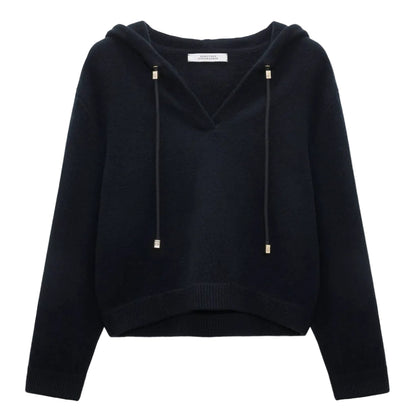 The Dorothee Schumacher Modern Statements Pullover is a black, long-sleeve cropped hoodie with a V-neck, metallic-tipped drawstrings, and a boxy fit for contemporary comfort.