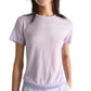 A person wears the Dorothee Schumacher Natural Ease Shirt in light purple heather with tonal knit trim and light blue pants, shown from shoulders to hips against a plain background.