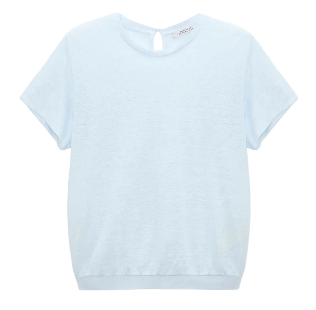 The Natural Ease Shirt by Dorothee Schumacher is a light blue heathered top with short sleeves, a crew neck, and a small buttoned keyhole at the back neckline, shown against a plain white background.