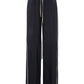 The Dorothee Schumacher Casual Attraction Pants are black wide-leg wool joggers with white side stripes, a relaxed fit, and an elastic drawstring waist, shown against a white background.