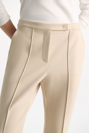 A person wearing Dorothee Schumacher Emotional Essence Pants, featuring a white color and cropped fitted design.