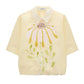 The Floral Power Blouse by Dorothee Schumacher is a light yellow cotton poplin top featuring a removable lace collar and a bold pastel pink, yellow, and green floral design on the front.