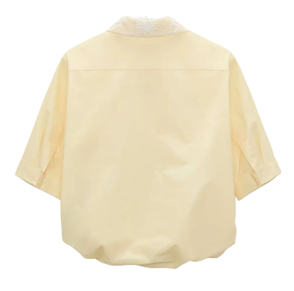 Back view of the Floral Power Blouse by Dorothee Schumacher in light yellow cotton poplin, featuring three-quarter sleeves, a loose fit, subtle upper collar embroidery, and a detachable lace collar for versatile styling.