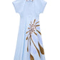The Floral Power Dress by Dorothee Schumacher is a light blue cotton poplin dress featuring a polo collar, button front, and a large brown and white signature flower print on the lower half.
