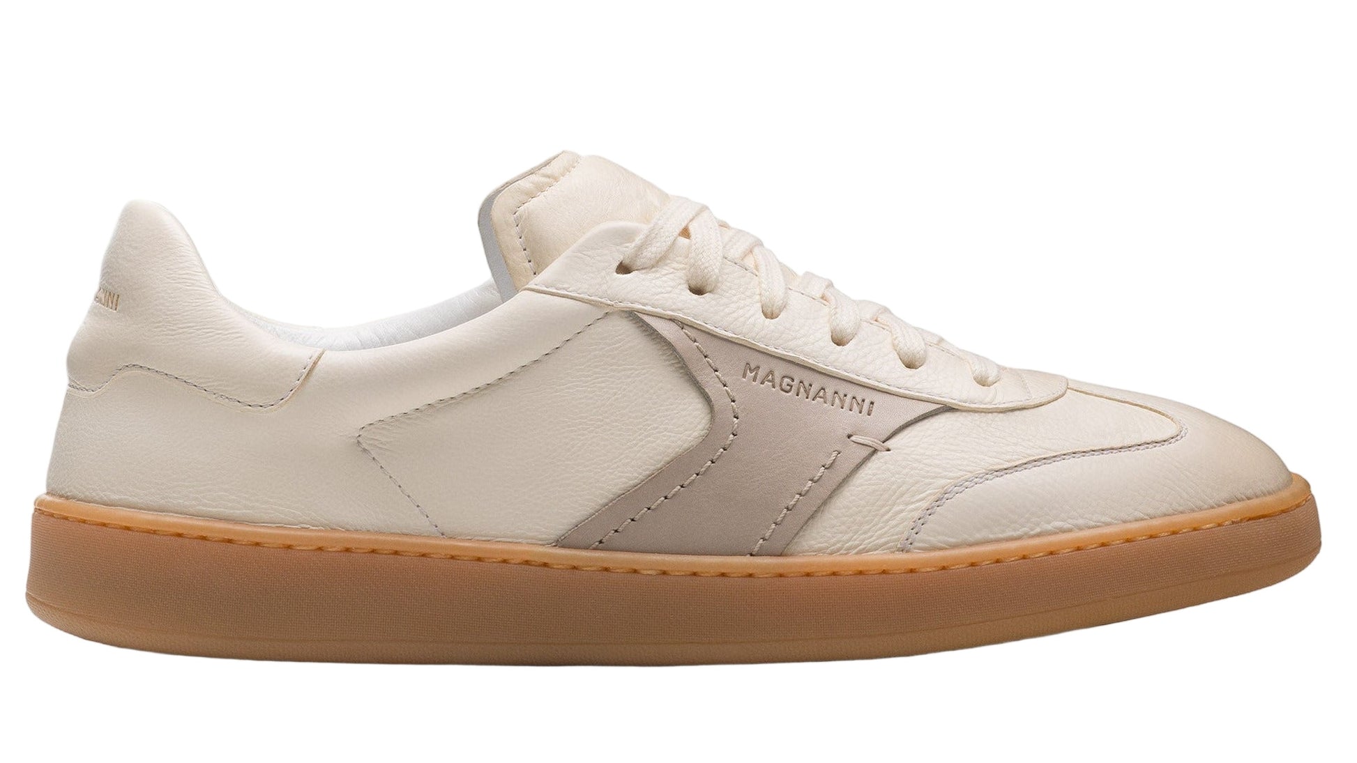 The Magnanni Zori Sneaker is a vintage-inspired shoe with a white leather upper, tan rubber sole, lace-up front, and subtle "Magnanni" branding on the side.