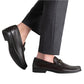 A person in charcoal trousers and Magnanni's dark Gentry Soft Bit Loafers with a chic moccasin design steps forward.