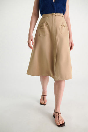 A person in a sleeveless blue top, brown sandals, and the Dorothee Schumacher Luxury Layer Skirt walks forward against a plain light background.