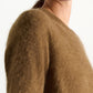 A person is shown from the shoulder up against a plain background, wearing the Dorothee Schumacher Fluffy Statements Pullover—a brown, extra soft short-sleeve knit sweater.