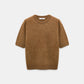 The Fluffy Statements Pullover by Dorothee Schumacher, a short-sleeved brown knit merino-cashmere sweater, is displayed on a plain white background.